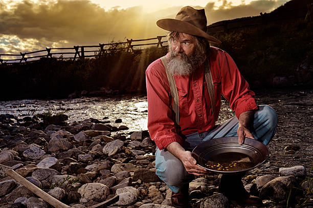 old-prospector-panning-for-gold-in-a-western-sunset.jpg